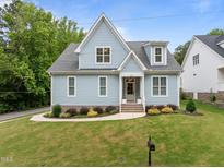 Charming blue two-story home with manicured lawn, landscaped garden, and inviting entryway at 622 Sunset Ave, Apex, NC 27502