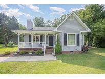 Charming single Gathering home with a well-maintained lawn and inviting front porch at 701 Creekside Dr, Clayton, NC 27520