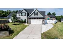 Beautiful two-story home featuring a two-car garage and well-manicured lawn with a long concrete driveway at 77 Redpine Ct, Clayton, NC 27520