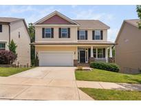 Charming two-story home with a well-manicured lawn, attached two-car garage, and inviting front porch at 817 Stable Fern Dr, Fuquay Varina, NC 27526