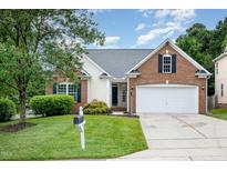 Charming brick home featuring a manicured lawn, attached garage, and inviting curb appeal at 9612 Treymore Dr, Raleigh, NC 27617