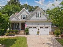 Charming two-story home with a two-car garage, a landscaped yard, and a welcoming front porch at 1161 Golden Star Way, Wake Forest, NC 27587