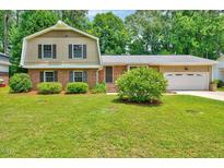 Charming brick home with well-maintained lawn and mature landscaping at 1209 Lochcarron Ln, Cary, NC 27511