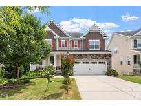Charming two-story home with a well-manicured lawn, a two-car garage and inviting front porch at 125 Durban Meadow Dr, Holly Springs, NC 27540
