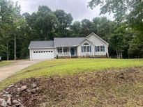 Charming single-story home featuring a blue front door, gray siding, and an attached two-car garage at 125 Tast Dr, Wendell, NC 27591