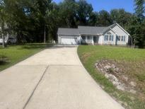 Charming single-story home with a two-car garage and a well-manicured front lawn at 125 Tast Dr, Wendell, NC 27591