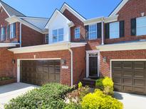 Inviting brick townhouse with a two-car garage and well-maintained landscaping at 129 Grande Dr, Morrisville, NC 27560