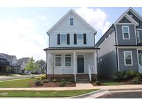 Charming two-story home with light blue siding, black shutters, and a welcoming front porch at 1534 Millrock Trl, Wendell, NC 27591