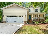 Charming yellow two-story home featuring a spacious garage, inviting porch, and well-manicured lawn at 2721 Rustic Brick Rd, Raleigh, NC 27603