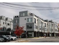 Modern townhome exterior with a gray and white color scheme and a red tree in the front at 3007 Corbell Rd, Durham, NC 27701