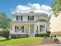 Charming two-story home featuring a covered front porch, well-maintained lawn, and classic architectural details at 3303 Glen Currin Dr, Raleigh, NC 27612