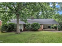 Charming brick home featuring a covered carport and lush landscaping at 3304 Redbud Ln, Raleigh, NC 27607