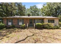 Charming single-story brick home featuring green shutters and a well-maintained front yard at 4038 Redwood Rd, Durham, NC 27704