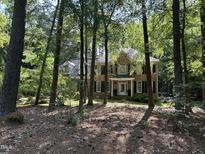 Charming brick two-story home with a manicured lawn and mature trees at 5109 Makena Dr, Raleigh, NC 27615