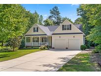 Charming single-story home with a well-manicured lawn, covered porch, and two-car garage at 59 Carrousel Ct, Angier, NC 27501