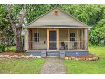 Charming single story home featuring a cozy screened porch and landscaped front yard with rock border at 611 Rowland St, Henderson, NC 27536