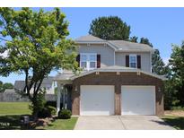 Charming two-story home with a well-maintained lawn, a two-car garage and brick accents at 740 Obsidian Way, Durham, NC 27703