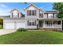 Charming two-story home with a well-manicured lawn, a two-car garage, and a welcoming front porch at 75 Mountainside Ln, Sanford, NC 27332