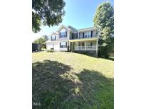 Two-story home with a charming front porch and a two-car garage nestled on a lush green lawn at 75 Mountainside Ln, Sanford, NC 27332