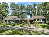 Inviting two-story home with beautiful landscaping, a charming front porch, and a long driveway lined by mature trees at 8156 Nc 42 Hwy W, Kenly, NC 27542