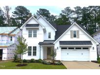 Beautiful two-story white home with a black metal awning, two-car garage, and well-manicured lawn at 9176 Dupree Meadow Dr # 17, Angier, NC 27501