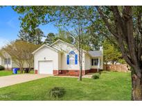 Charming single-story home with a well-manicured lawn, attached garage, and beautiful landscaping at 96 Landmark Dr, Angier, NC 27501
