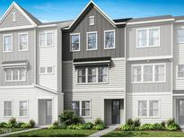 Charming townhome showcasing neutral tones, well-manicured landscaping and a welcoming entrance at 1041 Zelkova Ln, Chapel Hill, NC 27517