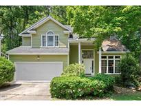 Charming two-story home featuring a two-car garage and a well-maintained front yard with mature landscaping at 107 Canyon Run, Cary, NC 27513