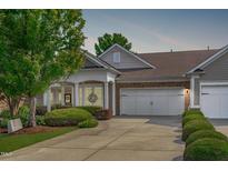 Charming single-story home boasting a manicured lawn, a two-car garage, and beautiful stone and siding accents at 128 Arvind Oaks Cir, Cary, NC 27519