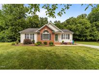 Charming one-story home featuring brick accents and a well-manicured lawn at 1383 Deercroft Ct, Graham, NC 27253