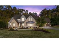 Stunning two-story stone home featuring manicured lawn and a side-entry garage on a wooded lot at 15517 Possum Track Rd, Raleigh, NC 27614