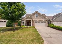 Charming single-Gathering home featuring a well-manicured lawn and an attached two-car garage at 1604 Vineyard Mist Dr, Cary, NC 27519
