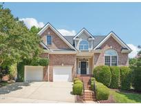 Beautiful two-story brick home with a manicured lawn, mature trees, and an attached garage at 1817 Wysong Ct, Raleigh, NC 27612