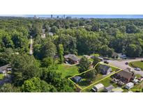 Expansive aerial view of property showcasing mature trees, spacious yard, and proximity to downtown skyline at 1818 Cecil St, Durham, NC 27707