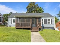 Charming single-story home featuring a screened front porch, gray siding, and a well-manicured lawn at 1818 Cecil St, Durham, NC 27707