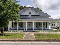 Charming home featuring a quaint front porch with rocking chairs and manicured landscaping at 212 W Church St, Benson, NC 27504