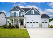 Charming two-story home with a welcoming front porch, three-car garage, and well-manicured lawn at 226 Castle Pond Way, Fuquay Varina, NC 27526
