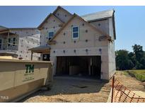 Exterior framing of two-story home in progress, showcasing its attached two-car garage and under-construction design at 267 Meadowbark Bnd # 34, Garner, NC 27529