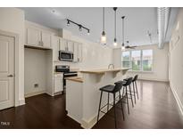 Modern kitchen with stainless steel appliances, granite countertops, and breakfast bar at 300 Finsbury St # 309, Durham, NC 27703