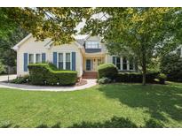 Charming home featuring manicured lawn, blue shutters, and lush landscaping at 304 Cayman Ave, Holly Springs, NC 27540
