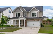 Charming two-story home with stone accents, manicured lawn, and inviting front porch at 309 Highland Forest Dr, Fuquay Varina, NC 27526