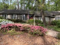 Charming single story home surrounded by lush flowering shrubs and mature trees, offering great curb appeal at 36A Country Club Dr, Rocky Mount, NC 27804