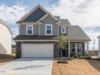 Two-story home featuring stone accents, a two-car garage, and a well-manicured front lawn at 417 Hipwood Dr, Zebulon, NC 27597