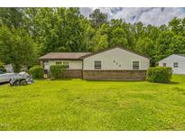 Charming single-story home features a well-maintained lawn and a classic brick foundation at 428 Walton St, Durham, NC 27703