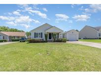 Charming one-story home with manicured lawn and attached garage on a sunny day at 6 N Carolina Ave, Benson, NC 27504