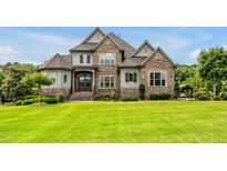 Beautiful, professionally landscaped home with stone and a large, well-manicured front yard at 6250 Moinear Ln, Chapel Hill, NC 27514