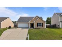 Charming single-Gathering home featuring a spacious two-car garage and a well-maintained front yard at 6920 Moss Creek Way, Rocky Mount, NC 27804