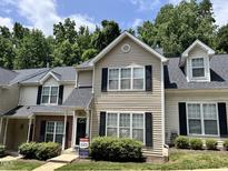 Traditional townhouse featuring neutral siding, black shutters, and a well-manicured lawn at 7331 Bonnie Ridge Ct, Raleigh, NC 27615