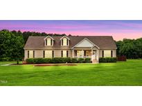 Charming home featuring a spacious front yard, manicured landscaping, and a welcoming covered porch at 9300 Lake Wheeler Rd, Fuquay Varina, NC 27526