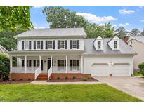 Inviting two-story home with a charming front porch and a two-car garage at 9425 Brimstone Ln, Raleigh, NC 27613